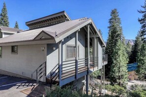 A two-story building with a balcony, a staircase, and a small attached structure with an American flag. - Eagle's Rest - Huntington Lake (Lakeshore)
