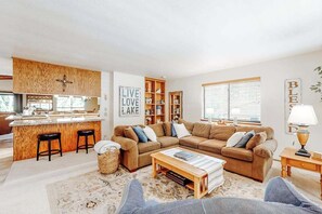 Un salon confortable avec un canapé, une table basse et un coin cuisine doté d’un bar.