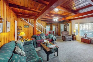 A cozy living room with a wooden interior, a sofa set, a coffee table, and a fireplace. - Casita Villareal - East Village (Shaver Lake)