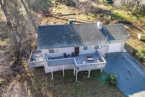 A two-story house with a covered porch and a fenced yard. - Pine Mountain Retreat (Groveland)