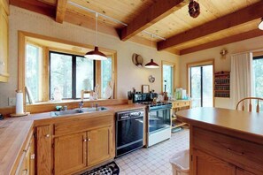 Eine geräumige Küche mit Holzausstattung, einem Geschirrspüler, einem Backofen und einer großen Kücheninsel.
