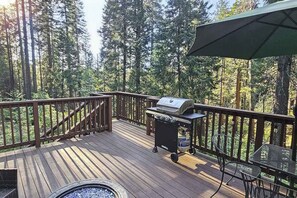 Eine Terrasse mit Grill, Stühlen und einem Feuerkorb.