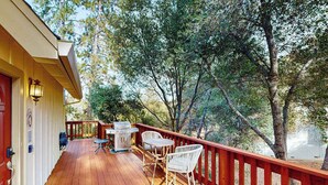A wooden deck with outdoor furniture, a grill, and a red railing. - Serendipity - Pine Mountain Lake (Groveland)