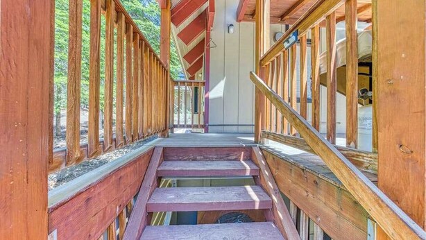 Una escalera de madera que conduce a un espacio cubierto con vistas al exterior.