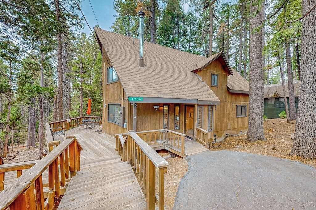 Eine Holzhütte mit Terrasse, umgeben von Bäumen.