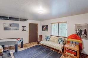 A room with a sofa, a table, and a window with blinds. - Forest Retreat - Blue Lake Springs (Arnold)