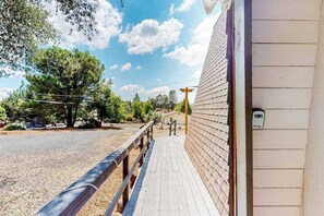 A wooden deck leading to a building with a white exterior wall. - Cozy Cabin - Pine Mountain Lake (Groveland)