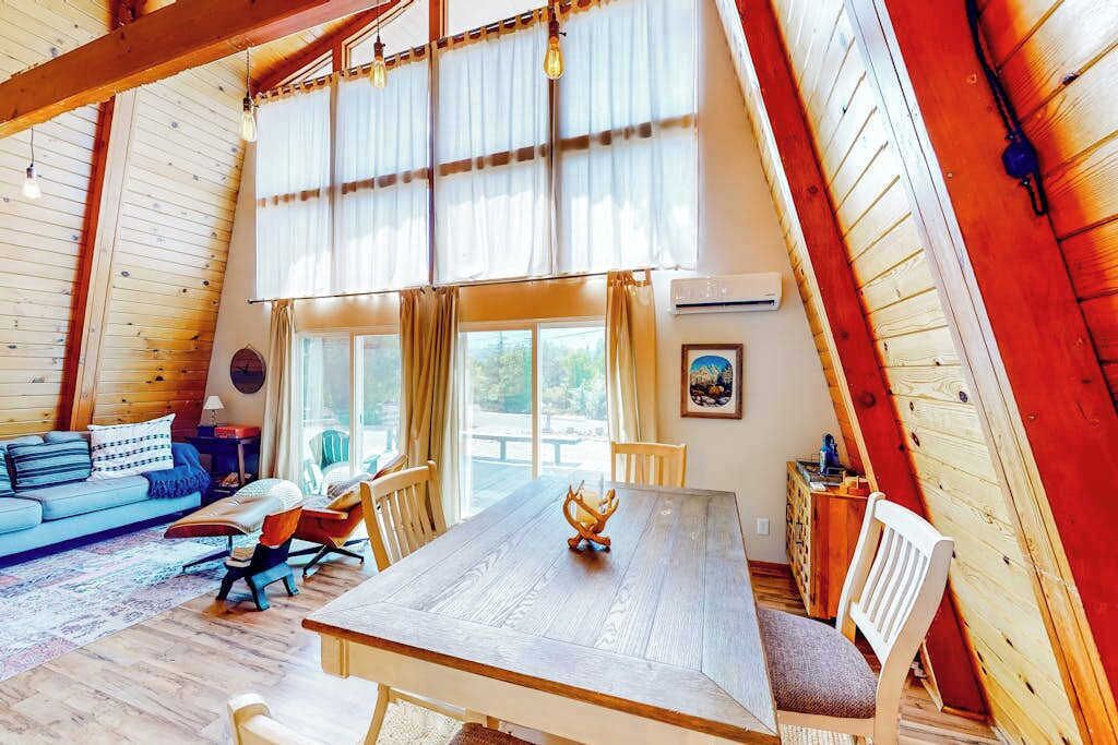 Une pièce confortable de style loft, avec un plafond en bois, une table à manger et un canapé.