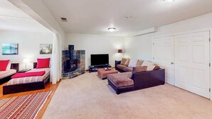 Una sala de estar moderna con chimenea, televisor de pantalla plana y un conjunto de sofás.