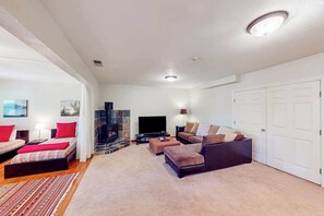 A modern living room with a fireplace, a flat-screen TV, and a sofa set. - The Lake Haus - Pine Mountain Lake (Groveland)