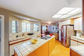 A modern kitchen with a central island, built-in appliances, and ample natural light. - The Lake Haus - Pine Mountain Lake (Groveland)