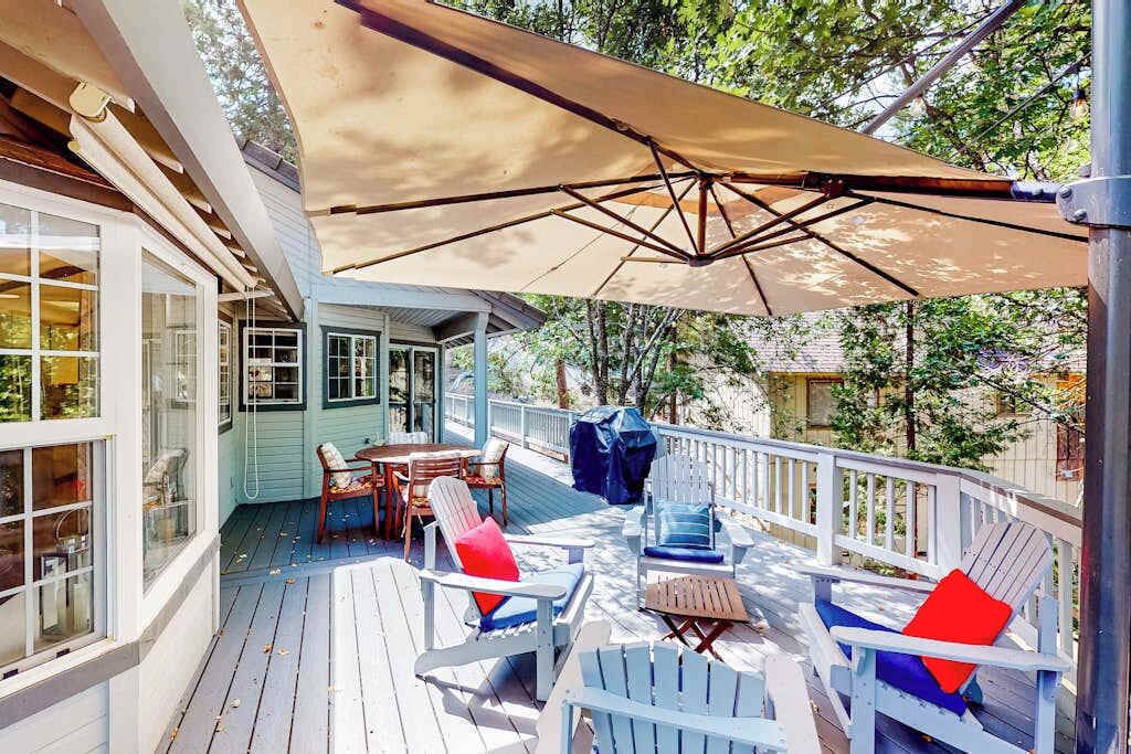 A covered deck with outdoor furniture and a large umbrella.