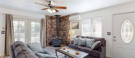 A living room with a sofa, a coffee table, a fireplace, and a door with a decorative glass panel.