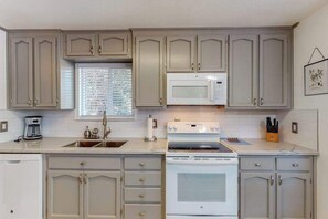A kitchen with a built-in microwave, stove, and sink. - Holiday Chalet - Pine Mountain Lake (Groveland)
