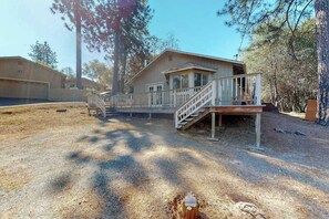 A two-story building with a front deck and a staircase leading to the entrance. - Holiday Chalet - Pine Mountain Lake (Groveland)
