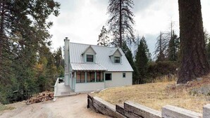 A rustic cabin with a sloped roof, a front porch, and a dirt driveway. - Foxtail Delight - West Village (Shaver Lake)