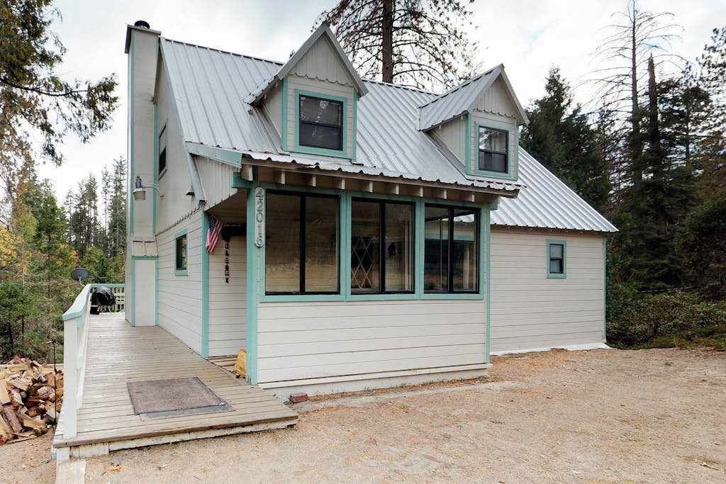 Un bâtiment à deux étages doté d’un porche, d’une cheminée et d’une antenne parabolique.