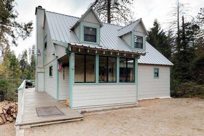 A two-story building with a porch, a chimney, and a satellite dish. - Foxtail Delight - West Village (Shaver Lake)