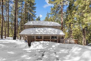 A two-story building with a covered porch and a snow-covered deck. - Bigfoot Cabin - Big Trees Village (Camp Connell)