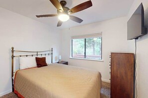 A bedroom with a bed, a ceiling fan, a window, and a television. - Deaver's Cabin - Dogwood Mountain (Shaver Lake)
