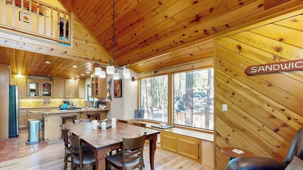 A wooden interior with a dining area, a kitchen, and a sign reading 'SANDWICH'. - Hot Tub Hideaway - Big Trees Village (Dorrington)