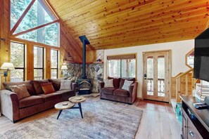 A cozy living room with two sofas, a fireplace, and large windows. - Hot Tub Hideaway - Big Trees Village (Dorrington)