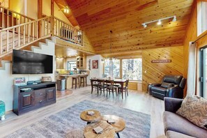 A spacious living area with a wooden ceiling, a dining table, and a leather sofa. - Hot Tub Hideaway - Big Trees Village (Dorrington)