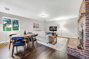 Ein modernes Wohnzimmer mit Essbereich, Kamin und großem Fenster.