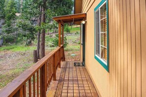 A wooden deck leading to a building with a green-framed window. - The Dollhouse Cabin - Blue Lake Springs (Arnold)