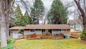 A single-story house with a front porch, a garage, and a yard with trees. - High Score Hideaway - Pine Mountain Lake (Groveland)