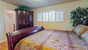 A bedroom with a bed, a wardrobe, a window with blinds, and a door. - High Score Hideaway - Pine Mountain Lake (Groveland)
