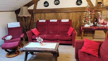 Ein gemütliches Wohnzimmer mit einem roten Sofagarnitur, einem Holztisch und einer Lampe.