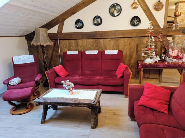 A cozy living room with a red sofa set, a wooden coffee table, and a lamp.