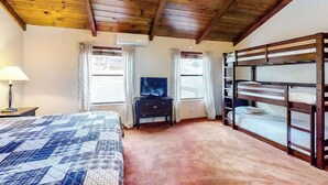 A bedroom with a bunk bed, a television on a dresser, and a ceiling fan. - Creekside Cabin - Pine Mountain Lake (Groveland)