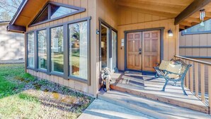 A wooden house with a porch, large windows, and a door. - Creekside Cabin - Pine Mountain Lake (Groveland)