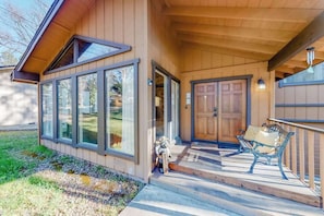 Ein Holzhaus mit Veranda, großen Fenstern und einer Tür.