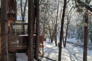 A cabin with a wooden deck and a view of a snowy forest. - Creekside Cabin - Pine Mountain Lake (Groveland)