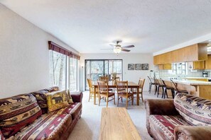Un salon comprenant un canapé, une table basse et un coin repas avec des chaises et une table.