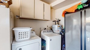 A laundry room with a washing machine, dryer, and stacked laundry baskets. - Creekside Cabin - Pine Mountain Lake (Groveland)
