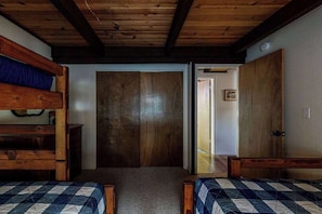 A room with two wooden bunk beds, a wooden door, and a small wooden dresser. - Pine Mountain Magic - Pine Mountain Lake (Groveland)