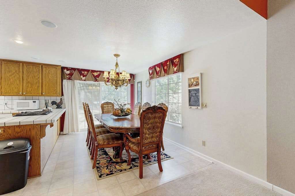 A dining area with a wooden table, chairs, and a chandelier.