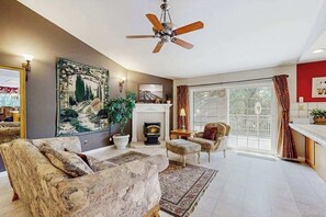 Ein Wohnzimmer mit Kamin, Deckenventilator und einem großen Gemälde.