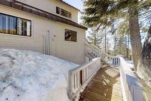 Un bâtiment à deux étages doté d’une terrasse en bois qui mène à un escalier.