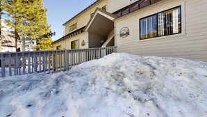 A building with a snow-covered front yard and a gated entrance. - Top Deck Retreat - Huntington Lake (Lakeshore)