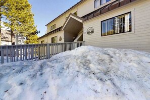 A building with a snow-covered front yard and a gated entrance. - Top Deck Retreat - Huntington Lake (Lakeshore)