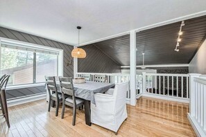 An indoor patio with a dining table, chairs, and a hanging light fixture. - Weekend at the Lake - Huntington Lake (Lakeshore)