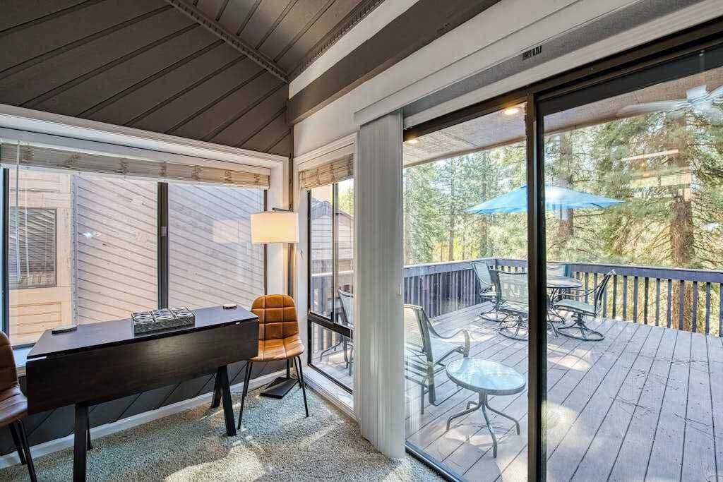 Ein Zimmer mit einer großen Schiebeglastür, die auf eine Terrasse mit Gartenmöbeln führt.