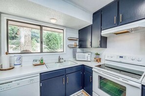 A modern kitchen with dark cabinets, a white countertop, a built-in microwave, and a double oven. - Weekend at the Lake - Huntington Lake (Lakeshore)