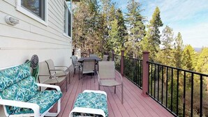 Eine Terrasse mit Gartenmöbeln und Blick auf Bäume.