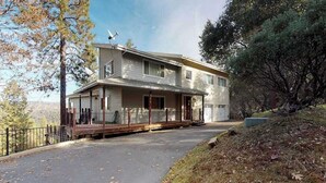 Ein zweistöckiges Haus mit überdachter Veranda, Garage und Satellitenschüssel.